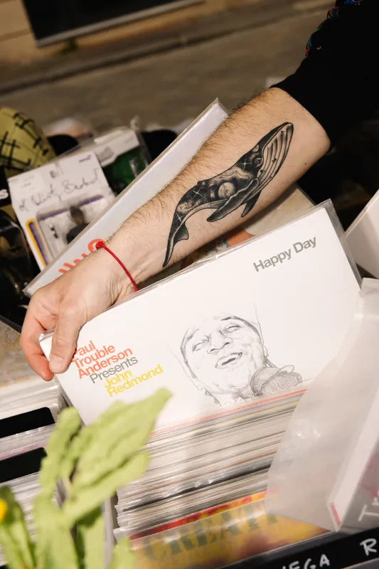 Mano con tatuaggio balena estrae vinile Happy Day